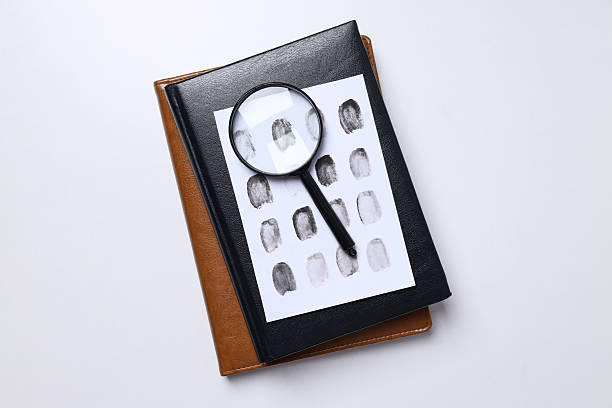 istock Books, magnifying glass with fingerprints on a white background 2210172220