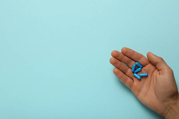 istock Blue viagra pills in a man's hand 2210173721