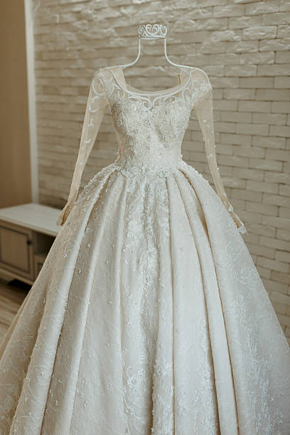 istock A long white dress with a long train is hanging on a hanger 2210174806