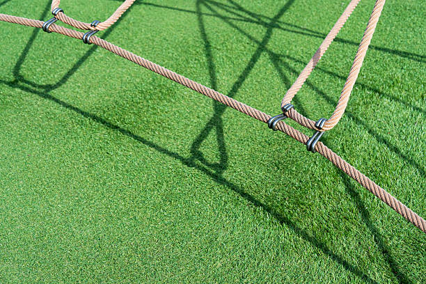 istock Rope climbing frame playground with shadow on green artificial turf grass mat texture quipment,Minimalist abstract backgroundCrop shot rope chain with metal knot lock 2210179424