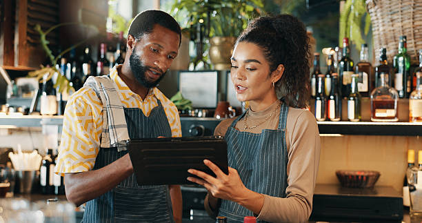istock Restaurant, teamwork and people on tablet for training for inventory, menu items and checklist by bar. Alcohol, business and man with woman on digital tech for hospitality, service and online order 2210179515