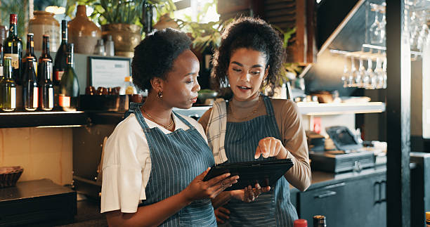 istock Restaurant, hotel and women on tablet for training for inventory, menu items and checklist by bar. Alcohol, business and waiter with manager on digital tech for hospitality, service and online order 2210179570