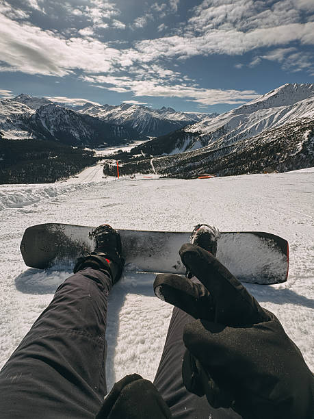istock Snowboarder resting on mountain top enjoying scenic view 2210183152