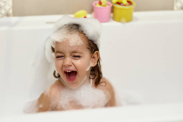 istock Joyful girl having fun in a bathtub 2210183664