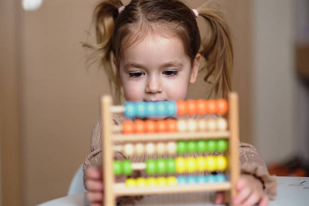 istock Girl learning how to count on abacus toy 2210185165