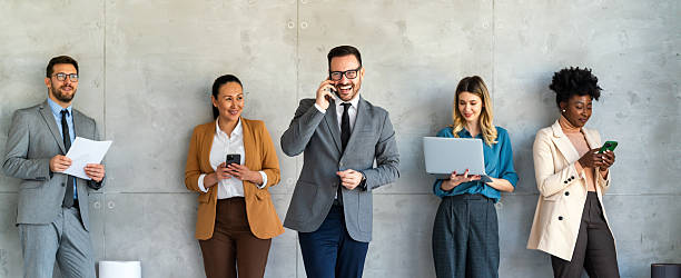 istock Busy smiling executive business team using digital devices in office. Diverse professional people 2210186374
