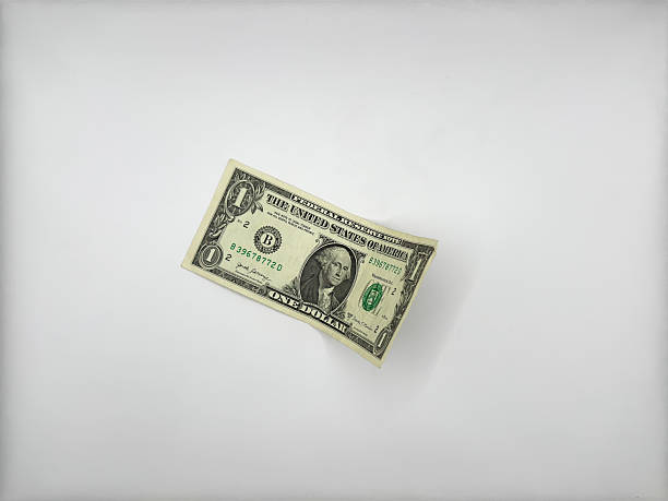 istock One dollar of the old design lies on a white background without unnecessary objects in the center of the image face up slightly bent on the right side view from above 2210187808