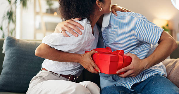 istock Love, gift and hug with couple on sofa for valentines day celebration, box or bonding. Relationship, thank you and romance with man and woman at home for support, connection or present together 2210189258