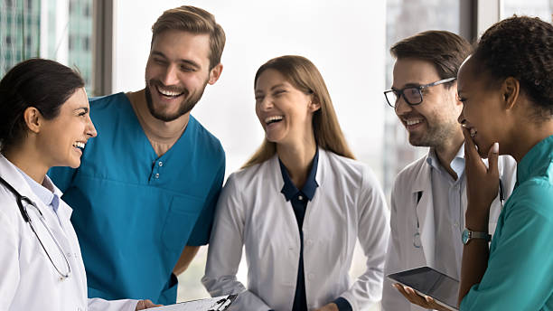 istock Friendly diverse multiethnic doctors laughing in group at hospital workplace 2210190157