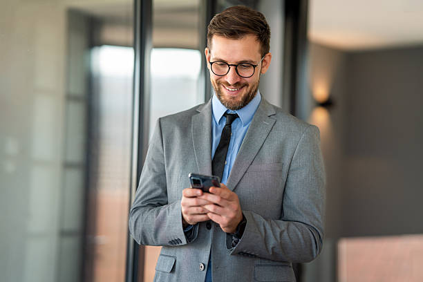 istock Happy businessman using mobile phone while analyzing weekly schedule in corporate office 2210190250