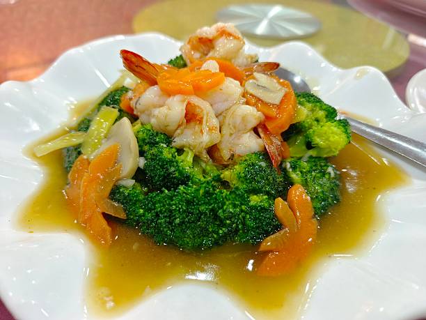 A plate of fried seafood, a classic Cantonese dish featuring shrimp and broccoli in garlic sauce