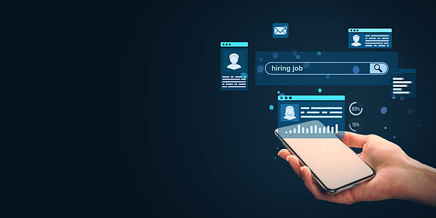 istock Person holding smartphone with digital hiring interface and candidate profiles on dark background, symbolizing online recruitment technology concept. 2210193326