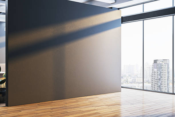 istock Blank black wall mockup in modern office interior with city view and sunlight streaming through large windows for poster or logo presentation. 3D Rendering 2210193429
