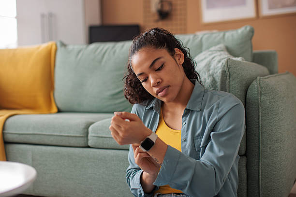 istock Young woman using her smart watch at home 2210193480