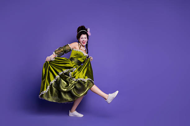 istock Young woman in a vibrant green gown posing dynamically against a vivid purple studio background 2210193708