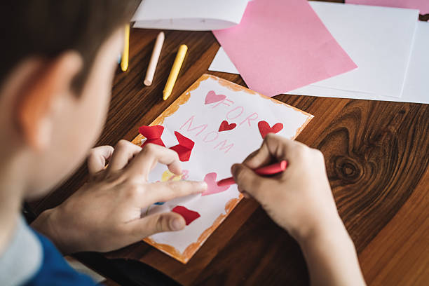 istock Little boy making greeting card for mother 2210193920