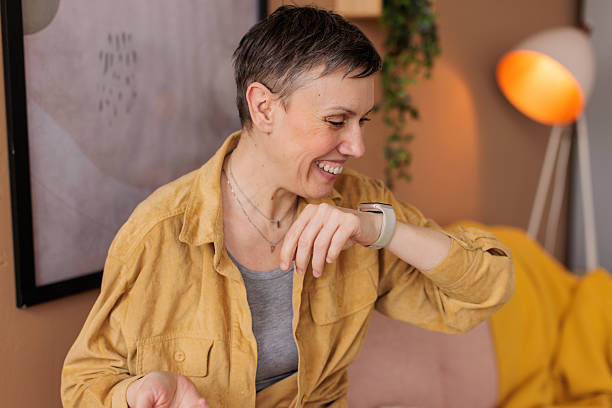 istock Woman talking on her smart watch at home 2210193942