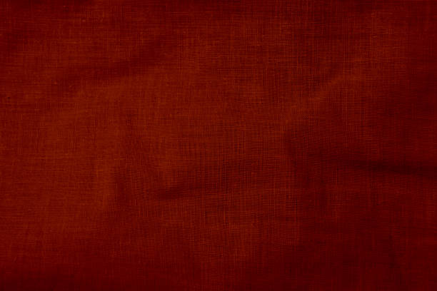 Close-up of a red textile fabric texture showing fine details, material weave, and subtle wrinkles, ideal for backgrounds, design concepts, or texture studies in fabric and material industries.