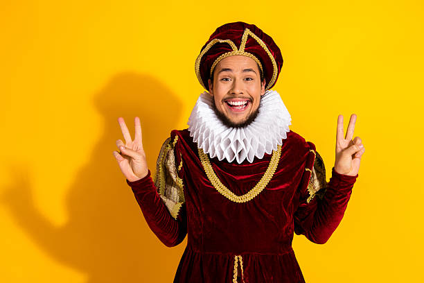 istock Young man in royal costume posing against a bright yellow background with a joyful expression 2210196894