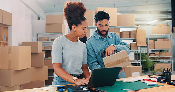 istock Box, laptop and planning with people in distribution warehouse for logistics or supply chain. Computer, conversation and shipping code with team in office for order delivery of cardboard packages 2210198174