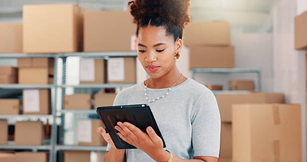 istock Tablet, delivery and shipping with woman in warehouse for logistics route, tracking code and cargo box. Inventory checklist, ecommerce with African person in factory for supplier distribution 2210198228
