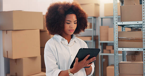 istock Tablet, inventory and shipping with woman in warehouse for logistics route, tracking code and cargo box. Checklist, ecommerce delivery with african person in factory for supplier distribution 2210198283