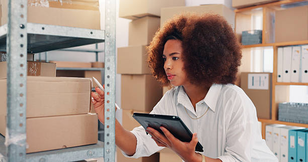 istock Tablet, inventory and box with woman in warehouse for logistics route, tracking code and cargo. Ecommerce, delivery and stock with african person in shipping factory for supplier distribution 2210198288
