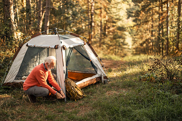 istock Senior Man Enjoys Camping Alone in a Tranquil Forest Setting 2210198440