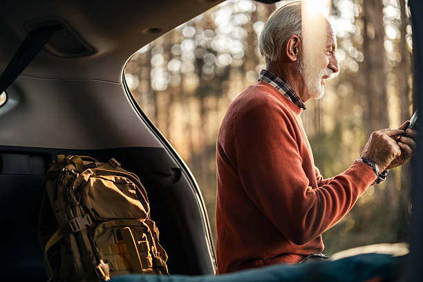 istock Senior Man Relaxing in SUV at Forest Campsite 2210198485