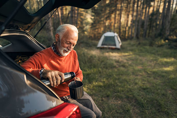 istock Senior Man Enjoying Camping and Tea in Forest Setting 2210198511
