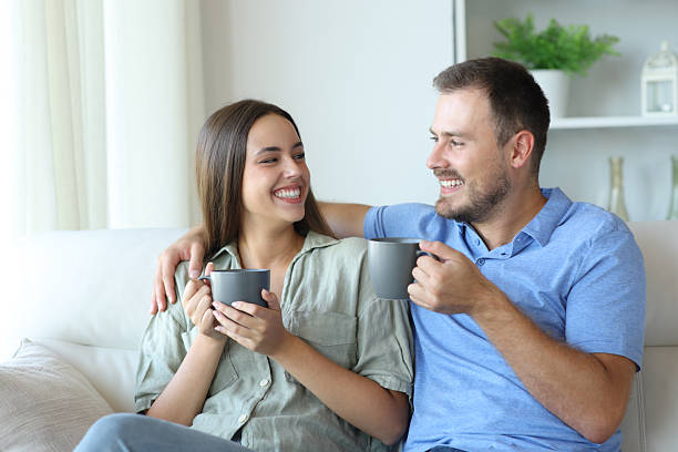 istock Happy couple looking each other at home drinking coffee 2210201311