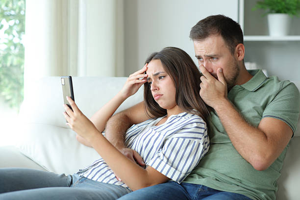 istock Worried couple checking online information on mobile phone 2210201408