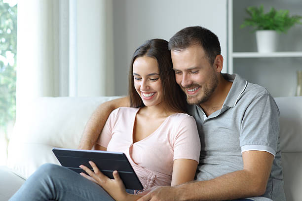 istock Happy couple watching online media on tablet at home 2210201558