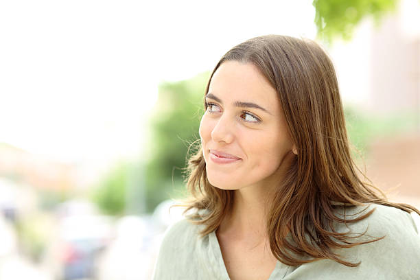 istock Satisfied woman looking at side thinking outdoors 2210201699