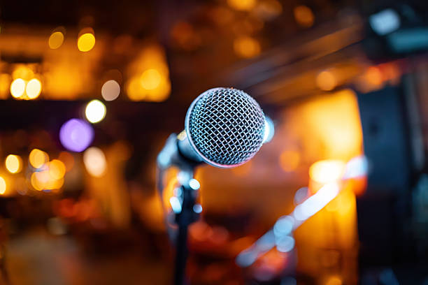 istock Microphone on stage against a background of auditorium. 2210202593