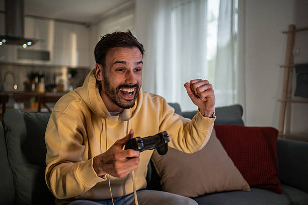istock Excited gamer winning videogame on console at home 2210206328