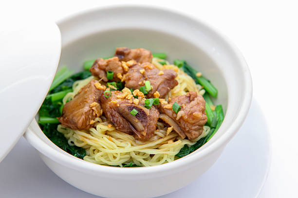 Noodle with Pork Rib Stew, Noodle with pork rib stew, served with fresh green vegetables in a white ceramic bowl, traditional Asian cuisine, top view, delicious and hearty meal