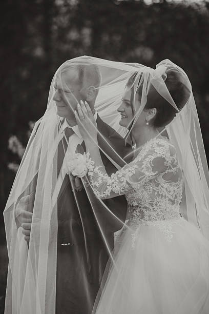 istock A bride and groom are hugging under a veil 2210208079