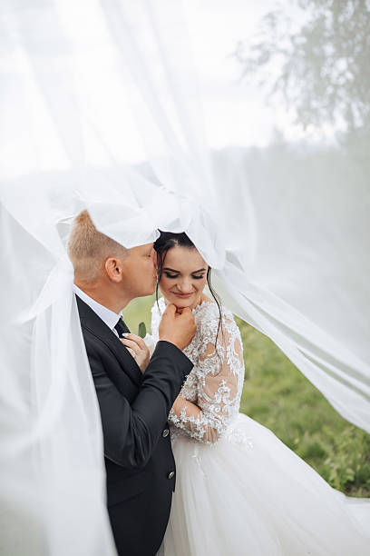 istock A man kisses a woman's neck under a white sheet 2210208212