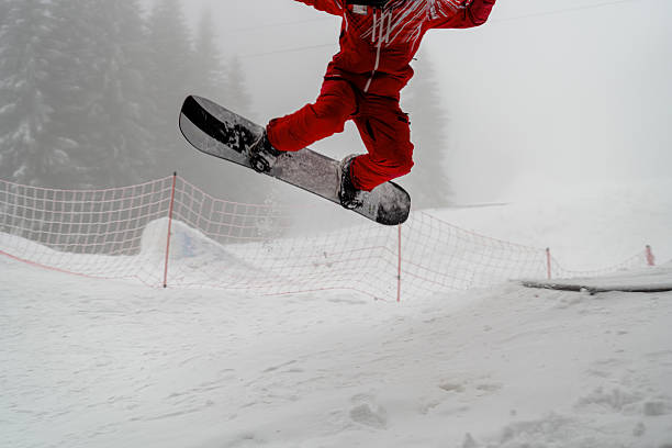istock Snowboarder performing a mid-air trick on a snowy mountain slope 2210212622