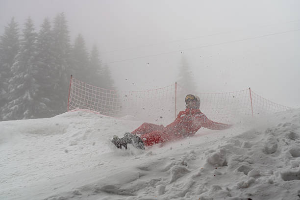Snowboarder sliding down the slope surrounded by a snowy misty landscape