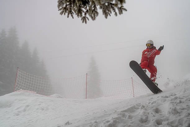 istock Snowboarder performing tricks on a snowy slope in winter landscape 2210213370