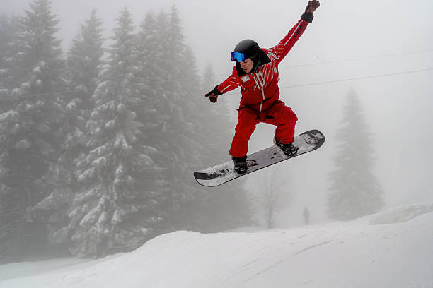 istock Snowboarder performing a midair stunt on a snowy hillside during winter 2210213551