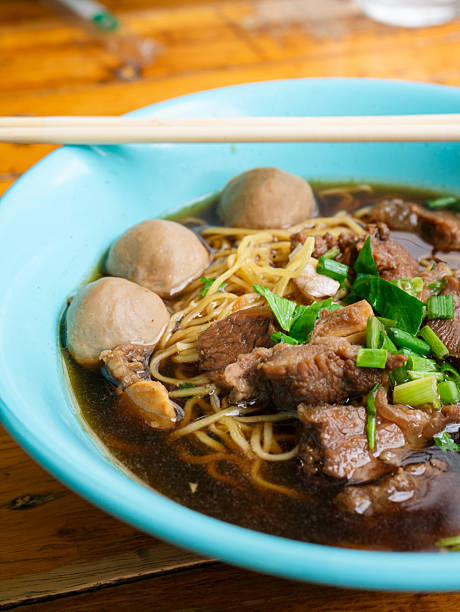 Braised beef noodle soup set on wooden table.