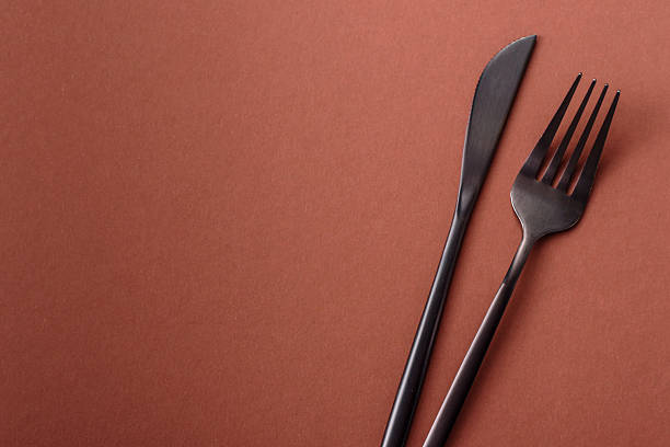 istock Knife and fork, cutlery on a brown dining table 2210217255