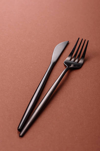 istock Knife and fork, cutlery on a brown dining table 2210217275
