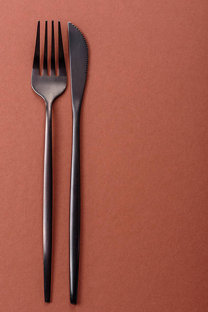 istock Knife and fork, cutlery on a brown dining table 2210217280
