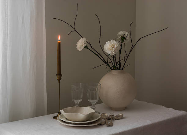 istock Empty dishes, a bouquet of carnations in a ceramic vase, a candle, cutlery - minimalistic setting 2210218055