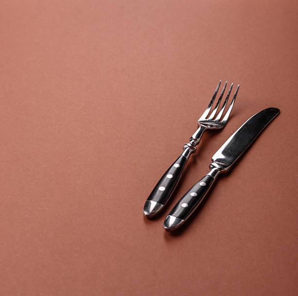 istock Knife and fork, cutlery on a brown dining table 2210218058
