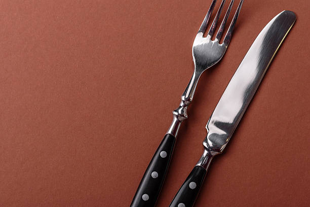 istock Knife and fork, cutlery on a brown dining table 2210218082